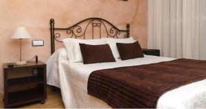 1 dormitorio con 1 cama grande y mesita de noche en Hostal Don Rodrigo en Zamora