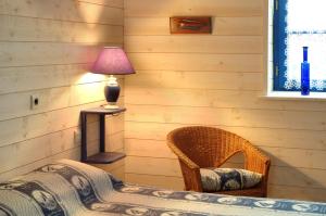 a bedroom with a bed with a lamp and a chair at La Jameliniere in Chailland
