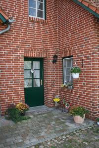 a green door on the side of a brick building at Ferienwohnung am Gibbach in Kirchlinteln