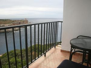 
a balcony overlooking a beach with a view of the ocean at Hotel Rocamar in Cala Figuera
