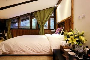 a bedroom with a large white bed with a window at Shangri-La mid - mountain homestay in Shangri-La