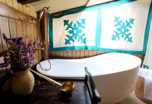 a bathroom with a tub and a vase of flowers at Shangri-La mid - mountain homestay in Shangri-La