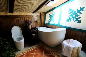 a bathroom with a tub and a toilet and a window at Shangri-La mid - mountain homestay in Shangri-La