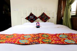 a doll sitting on top of a bed with a blanket at Shangri-La mid - mountain homestay in Shangri-La