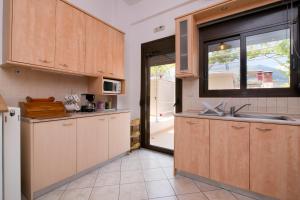 a kitchen with wooden cabinets and a sink at Meltemi Villa in Chrysi Ammoudia