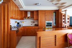 uma cozinha com armários de madeira e uma tigela de fruta no balcão em Ierapetra Seaview em Lerápetra