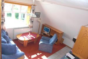 a living room with blue chairs and a table at Gästehaus Kapitän Jan Ricklefs in Nebel