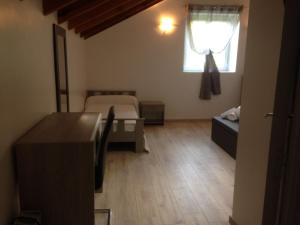 OliveseにあるFerme auberge du col de la vacciaのベッドと窓が備わる小さな客室です。