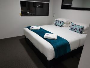 a bedroom with a large bed with towels on it at Hamilton on Beaumont in Newcastle