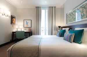 a hotel room with a large bed and a desk at Montfleuri in Paris