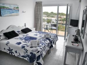 
a hotel room with a bed and a tv at Hotel Rocamar in Cala Figuera
