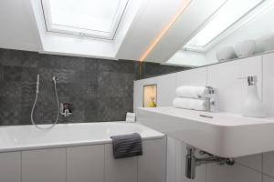 ein Badezimmer mit einem weißen Waschbecken und einem Dachfenster in der Unterkunft Haus Lukaswinkl in Schönau am Königssee