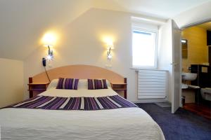 a bedroom with a large bed and a window at Hôtel Restaurant Le Sire de Joux in Montbenoît