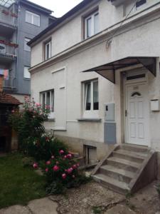 uma casa com uma porta branca e algumas flores cor-de-rosa em Apartmani Stonewood em Zagreb