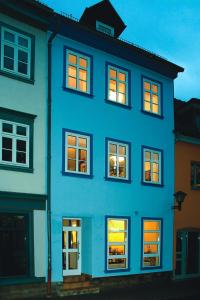 un edificio azul con luces en las ventanas en Stella Apartments am Erfurter Dom, en Erfurt