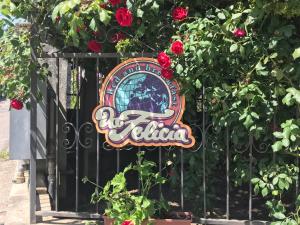 ein Schild an einem Tor mit roten Rosen in der Unterkunft Da Felicia in Cossato