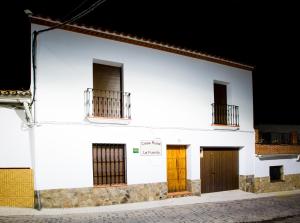 ein weißes Gebäude mit zwei Türen und zwei Fenstern in der Unterkunft Casa Rural La Fuente in Segura de León