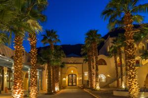 a courtyard with palm trees and lights at night at El Wekala Aqua Park Resort in Taba