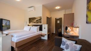 ein Hotelzimmer mit einem Bett und einem Sofa in der Unterkunft Rheinhotel Lamm in Rüdesheim am Rhein