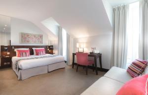 a bedroom with two beds and a desk and a chair at Montfleuri in Paris
