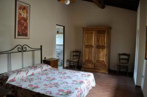 1 dormitorio con 1 cama y armario de madera en Agriturismo Soiano Famiglia Rolfini, en Montaione