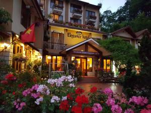 a hotel with flowers in front of a building at Sapa Elegance Hotel in Sapa