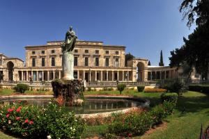 um grande edifício com uma estátua em frente a uma fonte em Sofias Flat em Corfu Town