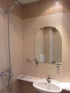 W łazience znajduje się umywalka i lustro. w obiekcie Family Hotel Bistritsa w mieście Sandanski