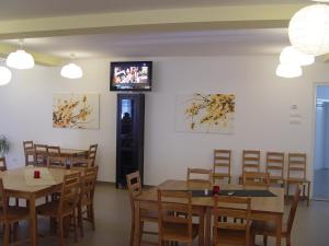 a dining room with tables and a tv on the wall at Hotel Astra in Braşov