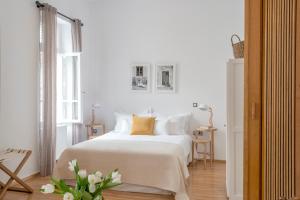 a white bedroom with a white bed and a window at Athens Residence Apartments in Athens
