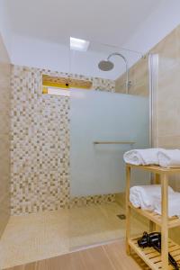 une salle de bain avec une douche avec une porte vitrée dans l'établissement Apartamento Victoria, à Vilamoura