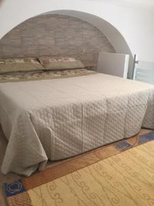 カターニアにあるCasa Mascagniのレンガの壁の客室で、大型ベッド1台を利用できます。