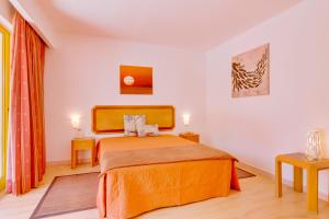 ヴィラモウラにあるApartamento Victoriaのベッドルーム1室(オレンジ色のベッドカバー付)