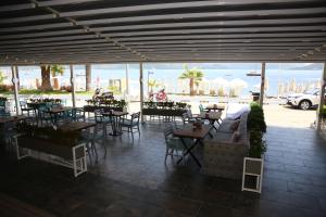 a patio with tables and chairs with a view of the ocean at Bliss Beach Hotel in Marmaris