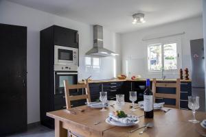 una cucina con tavolo in legno e una bottiglia di vino di Casa Candela a Tinajo