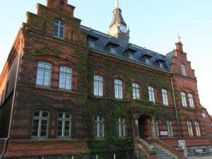 a brick building with a clock tower on top of it at Cavallino Herberge in Plau am See