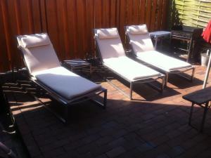a group of three chairs sitting on a patio at Cavallino Herberge in Plau am See +16 photos