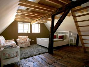a living room with a couch and chairs in a attic at Cavallino Herberge in Plau am See