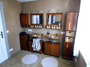 a bathroom with two sinks and two mirrors at Cavallino Herberge in Plau am See