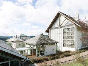 a white house with glass windows and a roof at Haus Feldberg-Falkau in Feldberg