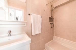 a bathroom with a sink and a toilet and a mirror at The Grafton Guest House in Llandudno +77 photos