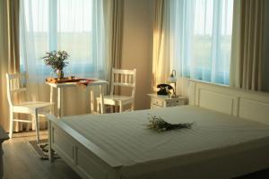 a bedroom with a large bed with two chairs and a table at Frăgăria in Zimandcuz