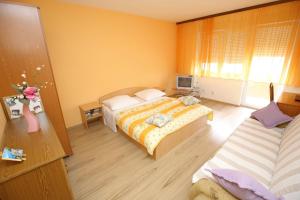 a hotel room with two beds and a television at Apartment Angela in Zadar