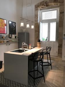 una cocina con una isla de cocina con 2 sillas en Casina Trento, en Siracusa