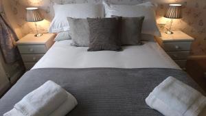 a large bed with pillows and two night stands at 103 Bewick Serviced Accommodation in Newton Aycliffe