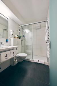 a bathroom with a toilet and a sink and a shower at Elite in Visp