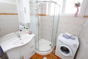 a bathroom with a shower sink and a washing machine at Apartment Angela in Zadar