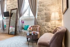 Habitación con 2 sillas y mesa con espejo. en Apartment and Rooms Stay, en Dubrovnik