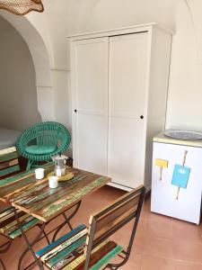 eine Küche mit einem Tisch und Stühlen sowie einem Kühlschrank in der Unterkunft Studio Alli in Pantelleria