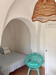Zimmer mit einem Bett und einem blauen Stuhl in der Unterkunft Studio Alli in Pantelleria